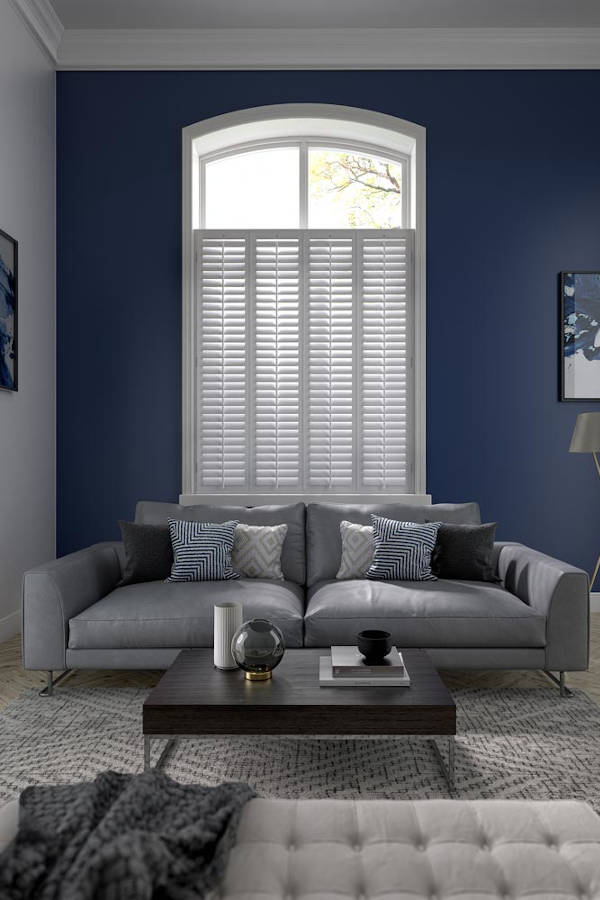 living room with sofa and large window with shutters