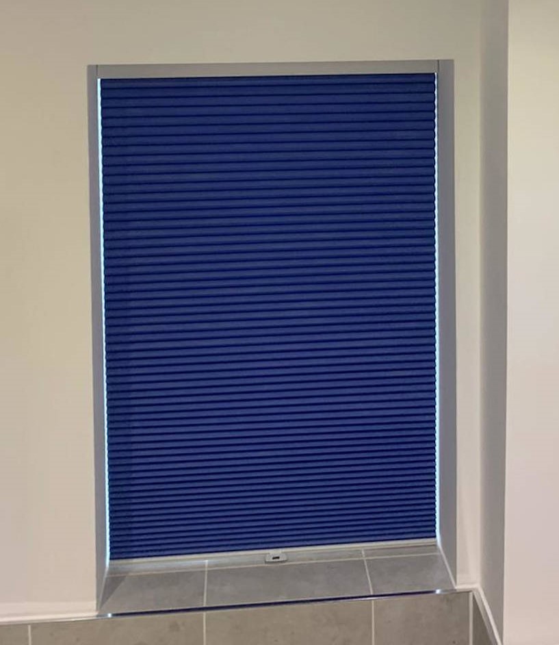 Bathroom window blind, coloured blue.
